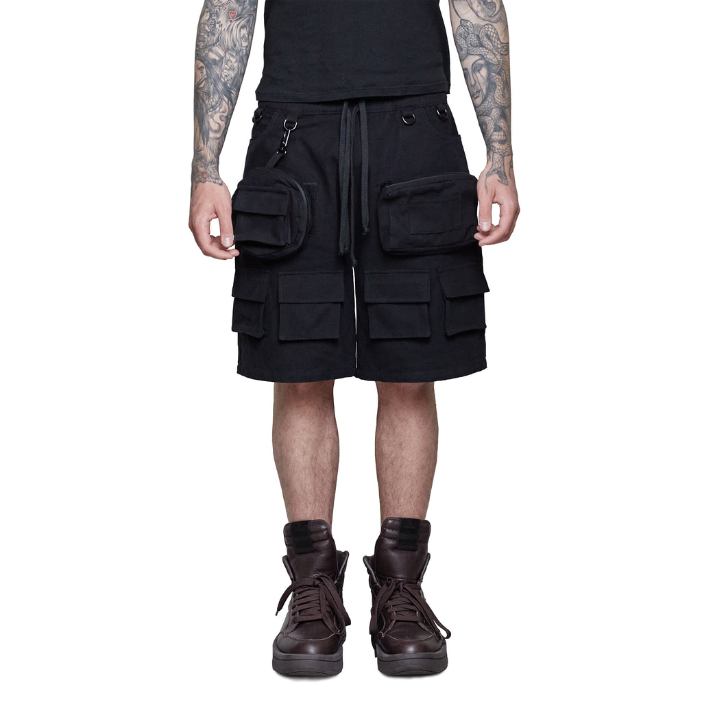 Person wearing Shinigami Couture black multipocket cargo shorts with boots front view