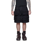 Person wearing Shinigami Couture black multipocket cargo shorts with boots front view